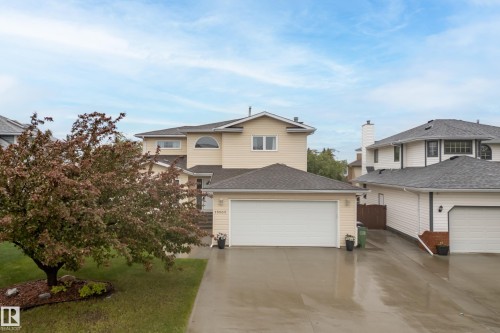Two-story residence featuring light-colored siding, a prominent two-car garage, and a gabled roofline - 15503 62 Street, Edmonton, AB 