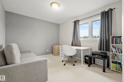 Light-colored carpeted flooring extends throughout this room, featuring light gray walls - 