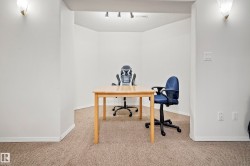 Carpeted interior space featuring white walls, white baseboards, and built-in wall sconces - 