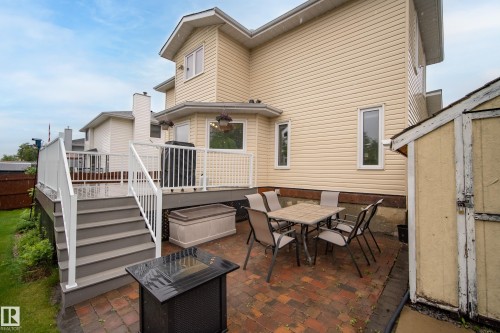 Rear exterior featuring a multi-level deck, a lower brick patio, and a storage shed - 15503 62 Street, Edmonton, AB 