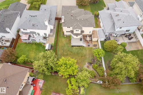 Expansive backyard featuring a large green lawn, mature trees, and a multi-level deck - 15503 62 Street, Edmonton, AB 