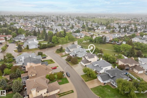 Aerial perspective showcasing a residential area with varied housing styles, mature trees, and paved streets - 15503 62 Street, Edmonton, AB 