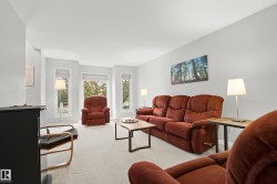 Living room featuring light-colored carpet flooring, multiple windows with blinds, and neutral wall tones - 