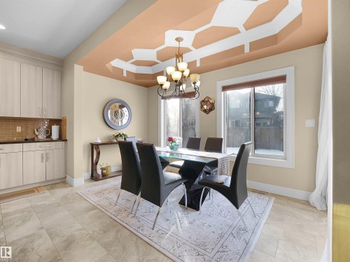 Breakfast Nook featuring a coffered ceiling with geometric detailing, a chandelier, and a large window - 2019 Cameron Ravine Way Nw, Edmonton, AB 