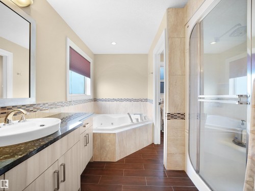 Bathroom featuring wood-finish flooring and a corner soaking tub - 2019 Cameron Ravine Way Nw, Edmonton, AB 