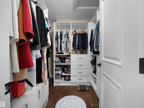 Custom white built-in closet system with multiple hanging rods and shelving - 2019 Cameron Ravine Way Nw, Edmonton, AB 