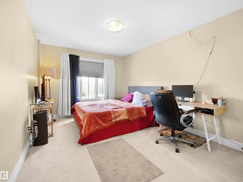 Carpeted room featuring a double window with blinds, light-toned wall paint, and a ceiling-mounted light fixture - 2019 Cameron Ravine Way Nw, Edmonton, AB 