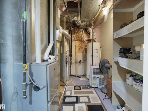 Utility area featuring a water heater, furnace, and exposed overhead ductwork - 2019 Cameron Ravine Way Nw, Edmonton, AB 