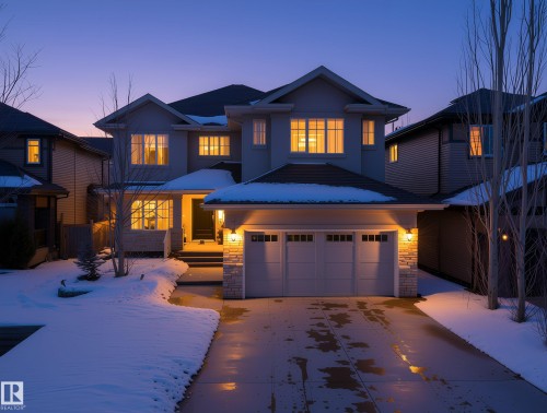 Two-story residence featuring a triple-car garage with overhead lighting and a stone accent column - 2019 Cameron Ravine Way Nw, Edmonton, AB 