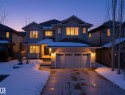Two-story residence featuring a triple-car garage with overhead lighting and a stone accent column - 2019 Cameron Ravine Way Nw, Edmonton, AB 