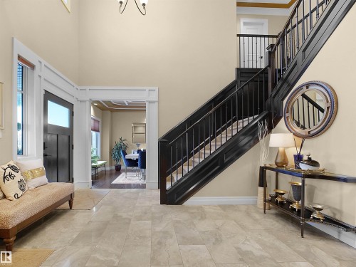 Foyer featuring a grand staircase with dark wood-finish newel posts and railings, complemented by iron balusters - 2019 Cameron Ravine Way Nw, Edmonton, AB 