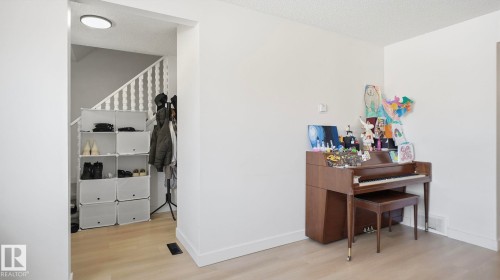 Light wood-finish flooring extending from the entryway into the room - 20C Callingwood Court, Edmonton, AB - Indoor Photo Showing Other Room