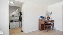 Light wood-finish flooring extending from the entryway into the room - 