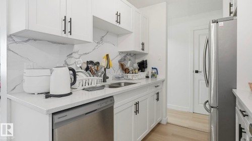 Modern kitchen featuring white shaker cabinetry with matte black hardware - 20C Callingwood Court, Edmonton, AB - Indoor Photo Showing Kitchen With Double Sink