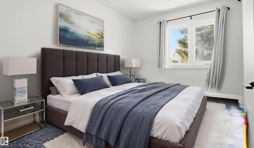 Light-filled bedroom featuring white walls and a large double-paned window - 20C Callingwood Court, Edmonton, AB - Indoor Photo Showing Bedroom