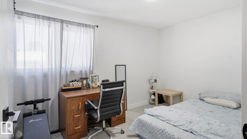 Bright interior room featuring white walls and light-toned carpet - 20C Callingwood Court, Edmonton, AB - Indoor Photo Showing Bedroom