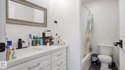 Bathroom featuring a white vanity with an integrated sink, matte black faucet, and a large framed mirror - 