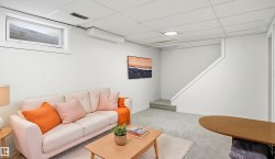 Carpeted living space featuring a drop ceiling, white walls, and a window - 