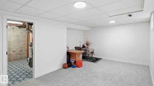 Finished basement room featuring light gray carpeting, white walls, and a drop ceiling with integrated lighting - 20C Callingwood Court, Edmonton, AB - Indoor Photo Showing Other Room