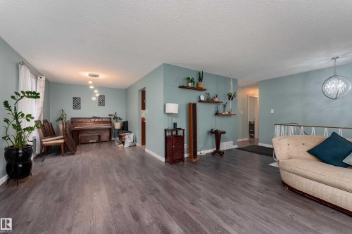 Spacious open-concept interior featuring wood-finish flooring throughout - 8011 44 Avenue, Edmonton, AB 
