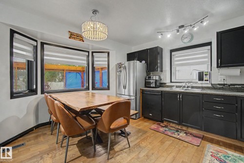 Kitchen area featuring wood-finish flooring and a bay window with black trim - 242 Northmount Drive, Wetaskiwin, AB 