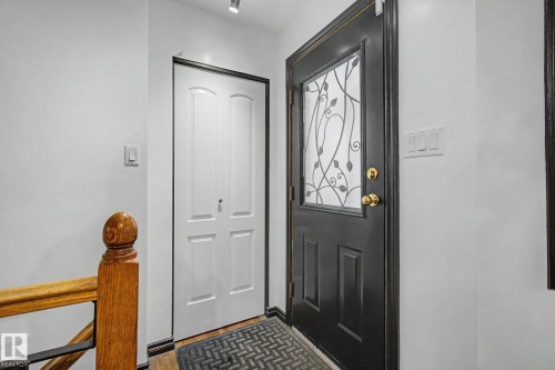 Black entry door with decorative glass insert - 242 Northmount Drive, Wetaskiwin, AB 