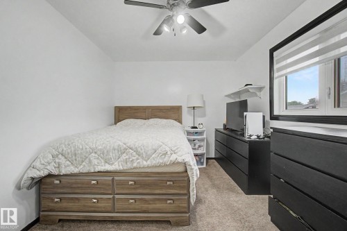 Room featuring neutral wall tones, light brown carpet, a ceiling fan with light fixture, and a window with horizontal blinds - 242 Northmount Drive, Wetaskiwin, AB 