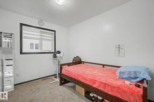 Bright interior room featuring a window with blinds, carpeted flooring, and white walls - 242 Northmount Drive, Wetaskiwin, AB 