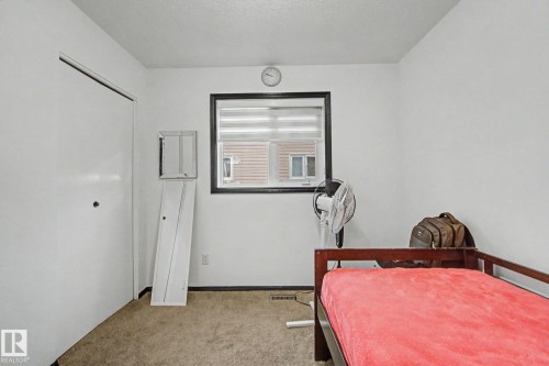 Room featuring a window with dark trim, light-colored walls, and carpet flooring - 242 Northmount Drive, Wetaskiwin, AB 