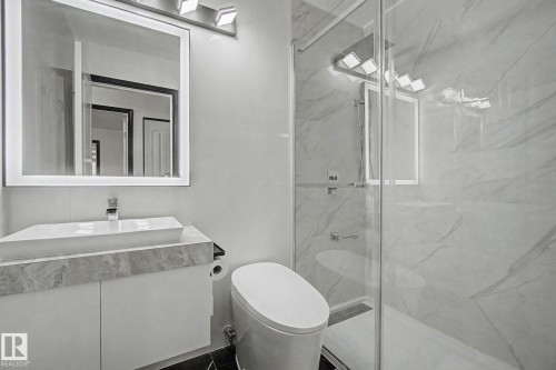 Contemporary bathroom featuring a floating vanity with a vessel sink, an illuminated mirror, and a walk-in shower with glass enclosure - 242 Northmount Drive, Wetaskiwin, AB 