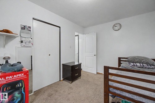 Neutral-toned carpet flooring with white walls and a white interior door - 242 Northmount Drive, Wetaskiwin, AB 