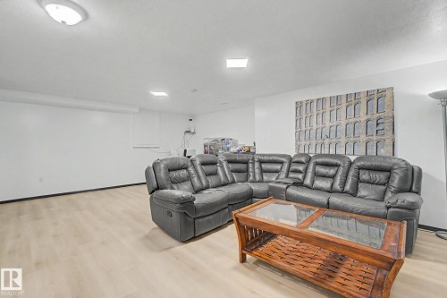 Spacious room with light wood-finish flooring and white walls - 242 Northmount Drive, Wetaskiwin, AB 