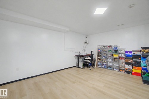Spacious room featuring light wood-finish flooring, white painted walls, and a recessed ceiling light - 242 Northmount Drive, Wetaskiwin, AB 
