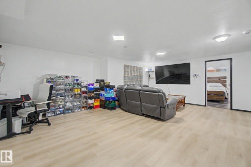 Spacious room featuring light wood-finish flooring, white walls, and recessed lighting - 242 Northmount Drive, Wetaskiwin, AB 