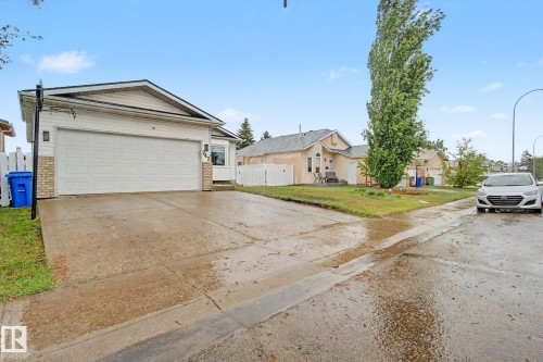 Single-story residence featuring a two-car garage with overhead door, vinyl siding, and brick accents - 242 Northmount Drive, Wetaskiwin, AB 