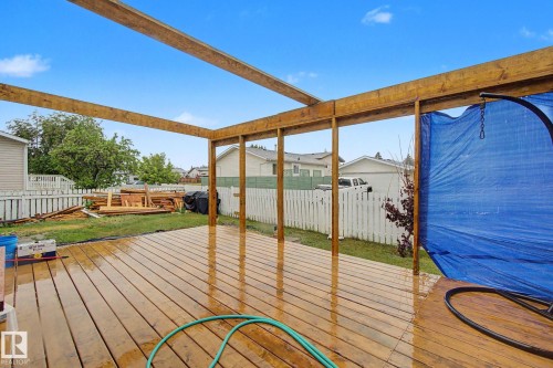 Spacious wood deck with a partial pergola structure, providing an outdoor extension to the property - 242 Northmount Drive, Wetaskiwin, AB 