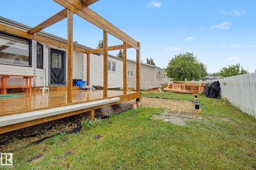 Outdoor wood-plank deck featuring a partial wooden pergola frame - 242 Northmount Drive, Wetaskiwin, AB 