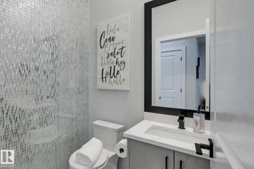 Powder room featuring a full-height mosaic tile accent wall - 54 Chartres Close, St. Albert, AB - Indoor Photo Showing Bathroom