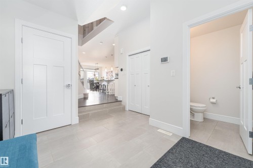 Spacious front entrance with tile flooring and 2 piece bathroom to wash up before entering the rest of the home - 3318 Parker Loop, Edmonton, AB - Indoor Photo Showing Other Room