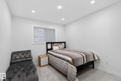 Recessed ceiling lighting illuminates a room with light gray walls and large format gray tile flooring - 