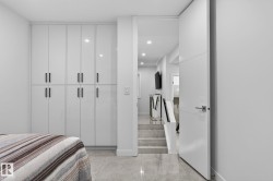 Integrated white high-gloss cabinetry featuring sleek black hardware - 