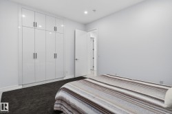 Floor-to-ceiling high-gloss white cabinetry featuring matte black hardware provides extensive storage - 