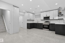 Modern kitchen featuring two-tone cabinetry with stainless steel hardware - 
