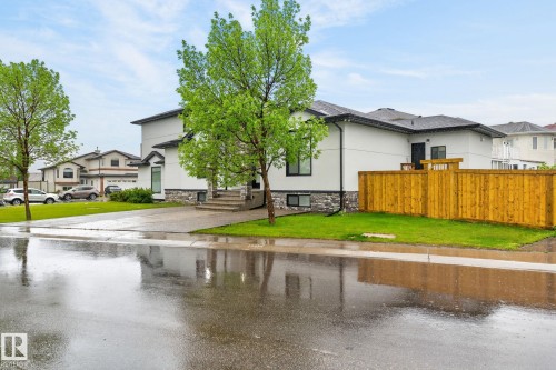 Contemporary residence featuring a white stucco exterior with stone accents and a dark-shingled roof - 7304 164 Avenue, Edmonton, AB - Outdoor
