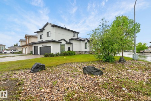 Contemporary white exterior with dark trim and a stone accent foundation - 7304 164 Avenue, Edmonton, AB - Outdoor