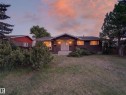 Ranch-style residence featuring dark brown siding and a dark shingle roof - 18416 90 Avenue, Edmonton, AB 
