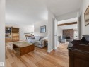 Spacious living area featuring wood-finish flooring, light-toned walls, and a built-in entertainment center - 18416 90 Avenue, Edmonton, AB 