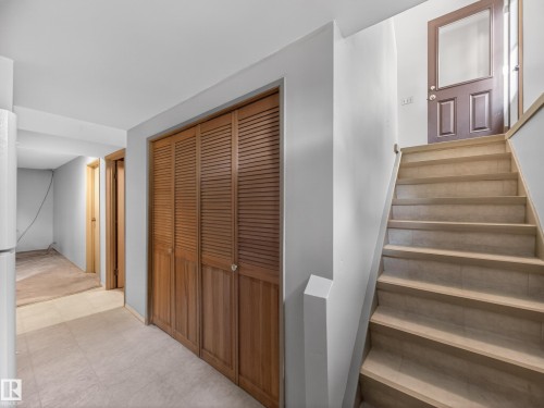 Interior staircase with light wood-finish treads and risers, featuring a white painted handrail - 18416 90 Avenue, Edmonton, AB 
