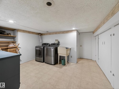 Dedicated laundry area featuring a utility sink and tile flooring - 18416 90 Avenue, Edmonton, AB 