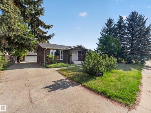 Brown siding exterior with white window trim and a concrete driveway - 18416 90 Avenue, Edmonton, AB 